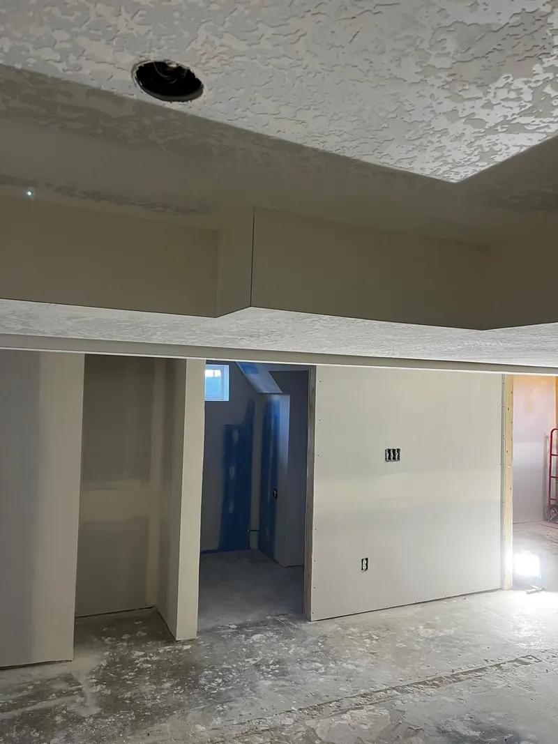 Basement soffit and knockdown ceiling finished around the doorway to a new bathroom