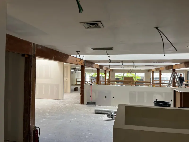 Commercial remodel with new drywall partitions taped and mudded between exposed timber posts and beams
