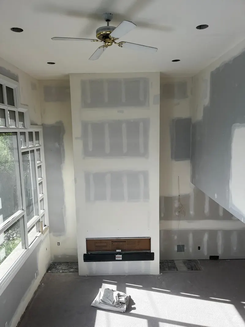 Living room fireplace chase in new drywall, taped and mudded around the fireplace insert
